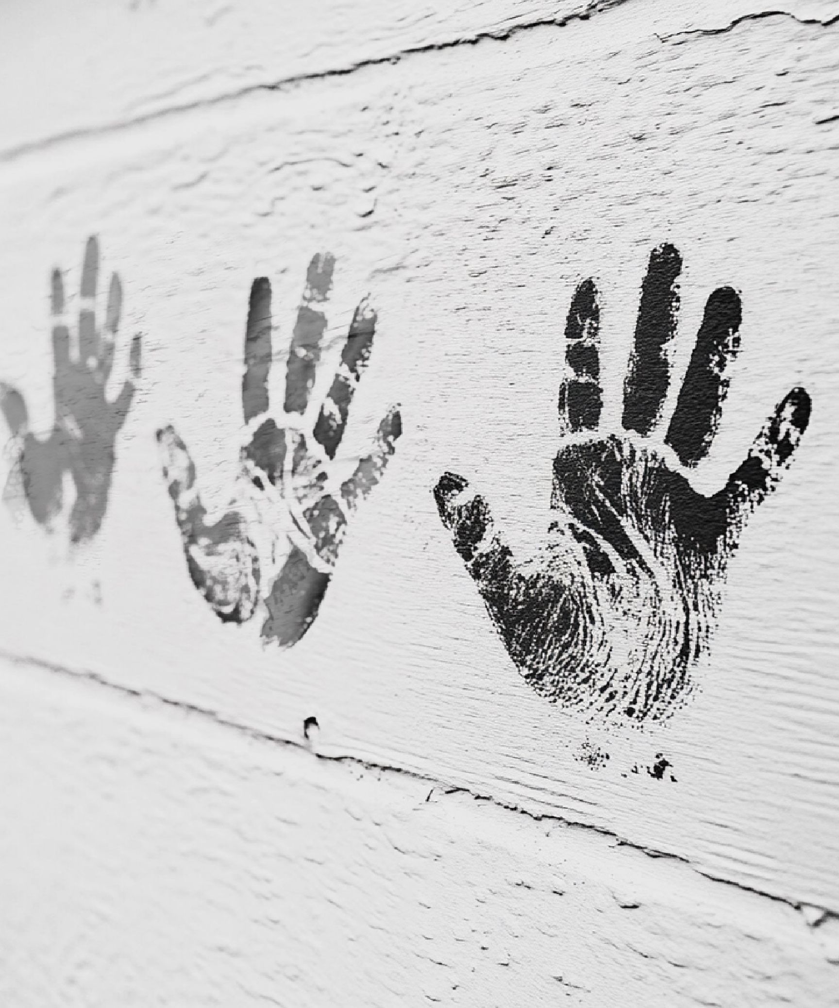 Kinderhände an einer Wand - schwarz-weiß