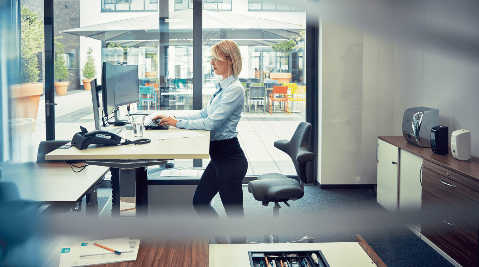 Eine Person steht am Schreibtisch