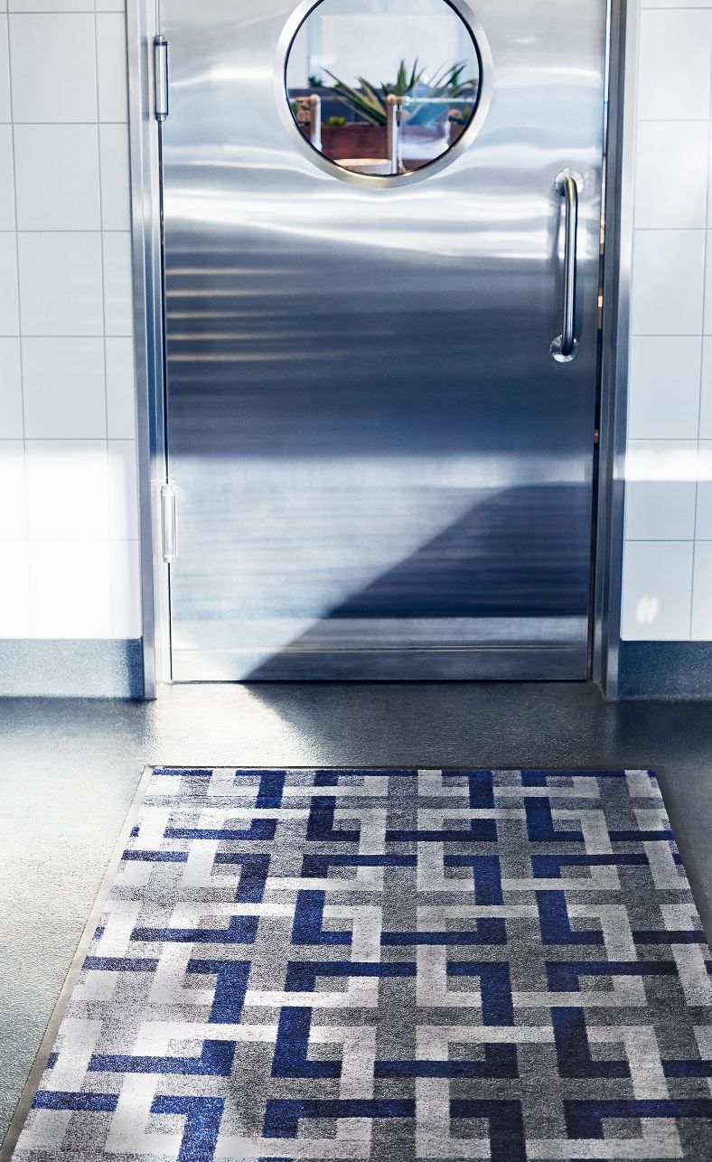 A carpet in front of a metal door